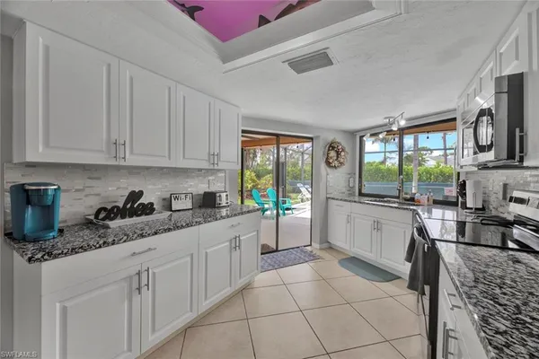 a kitchen with a stove a sink a refrigerator and window