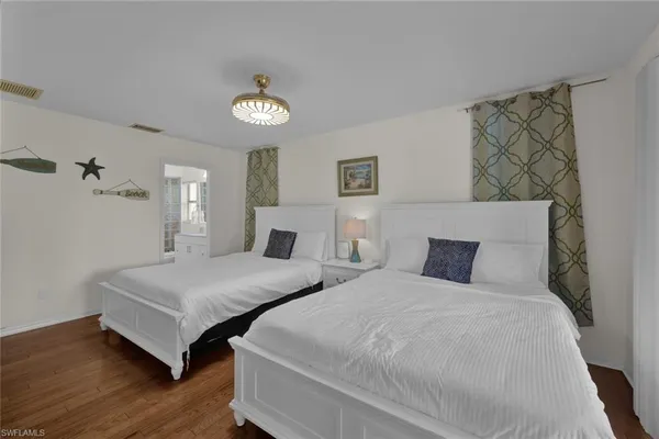 a bedroom with two beds and a chandelier