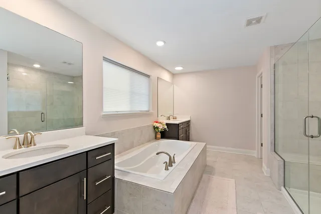 a bathroom with a tub sink and mirror