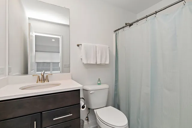 a bathroom with a sink a toilet and shower curtain