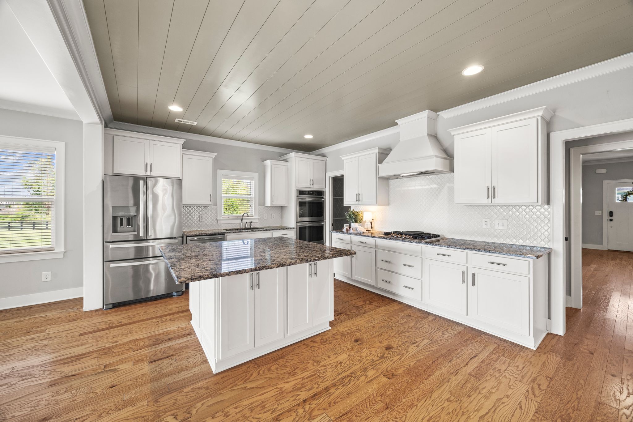 5001 Ryecroft Lane Franklin, TN 37064 - Photo 5 of 19 a kitchen with stainless steel appliances granite countertop a refrigerator a sink dishwasher a stove and white cabinets with wooden floor