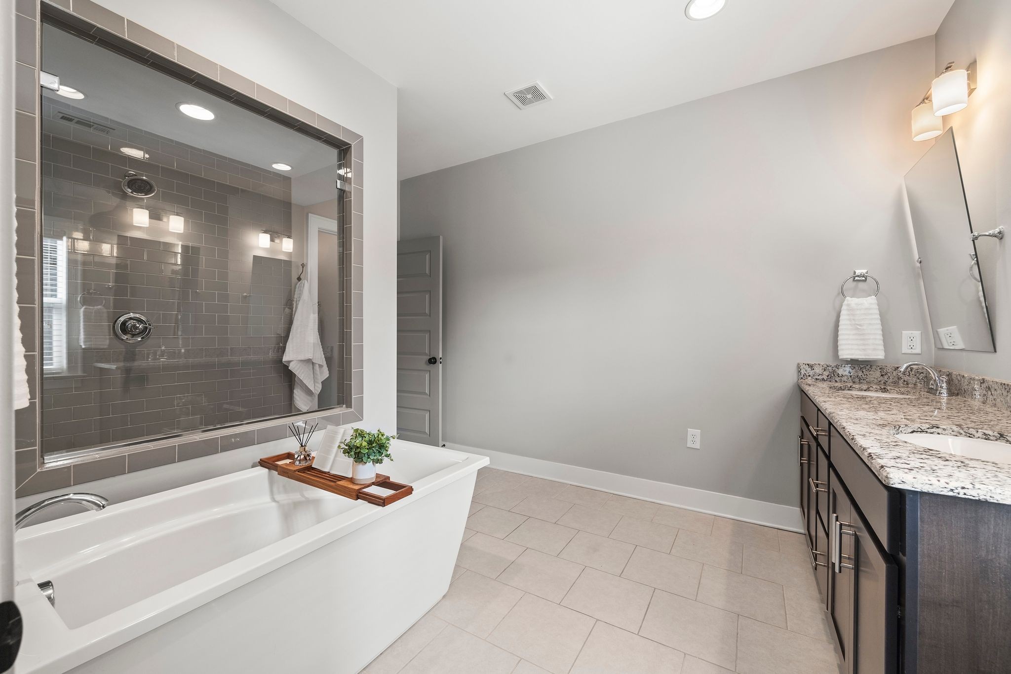 5001 Ryecroft Lane Franklin, TN 37064 - Photo 9 of 19 a bathroom with a granite countertop sink a mirror and a bathtub