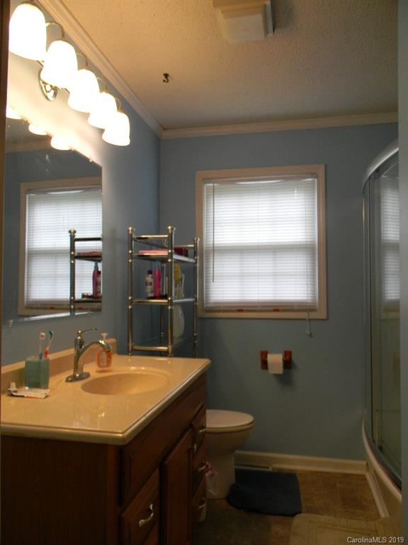 416 Willow Road Salisbury, NC 28147 - Photo 13 of 19 a bathroom with a sink a toilet a mirror and a window