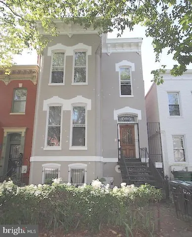 front view of a brick house with a yard