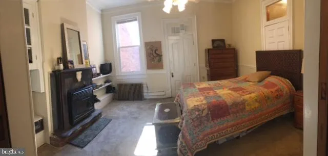 a spacious bedroom with a bed and a dresser next to a window
