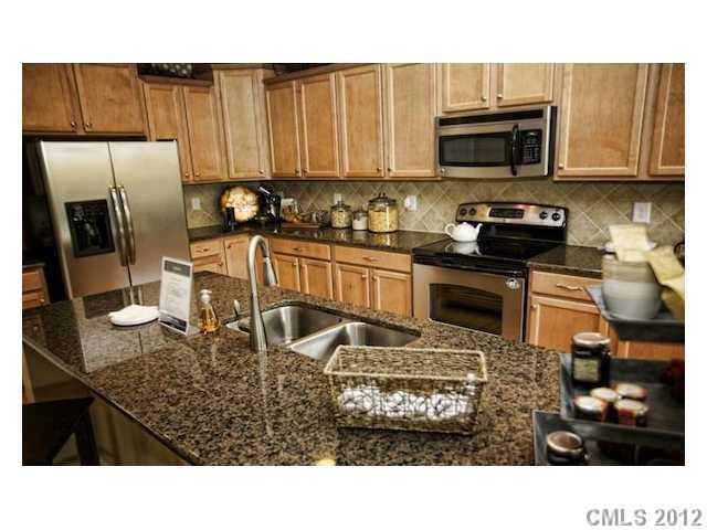 4022 Perth Road, Unit 169 Indian Land, SC 29707 - Photo 3 of 10 a kitchen with stainless steel appliances granite countertop a stove refrigerator sink and microwave