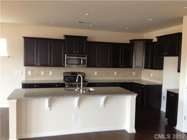 4022 Perth Road, Unit 169 Indian Land, SC 29707 - Photo 8 of 10 a kitchen with wooden cabinets a sink and a stove