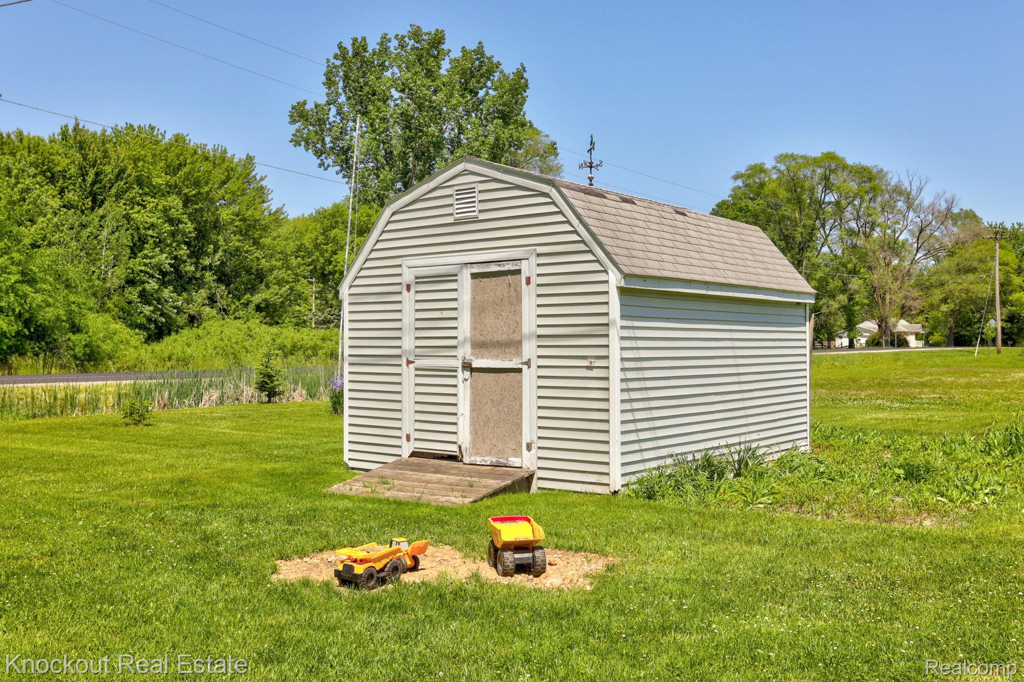 8845 Ormes Road Vassar, MI 48768 - Photo 32 of 35 Detached shed featuring light-colored siding, a gambrel roof, and double doors