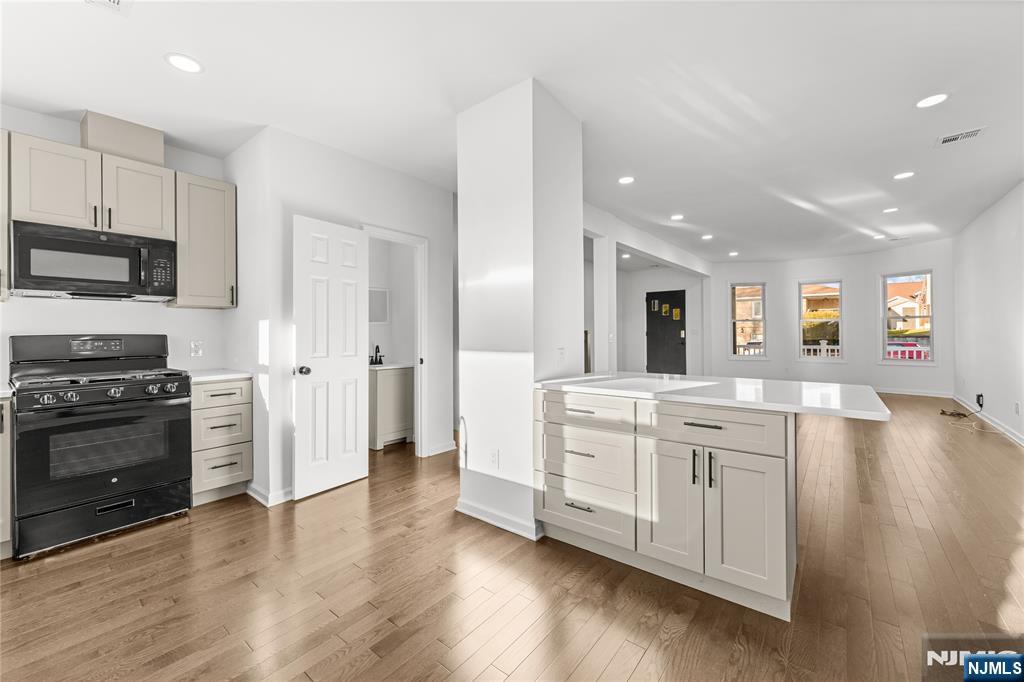 96 Prospect Terrace East Rutherford, NJ 07073 - Photo 7 of 31 a large kitchen with stainless steel appliances granite countertop a lot of counter space and wooden floor