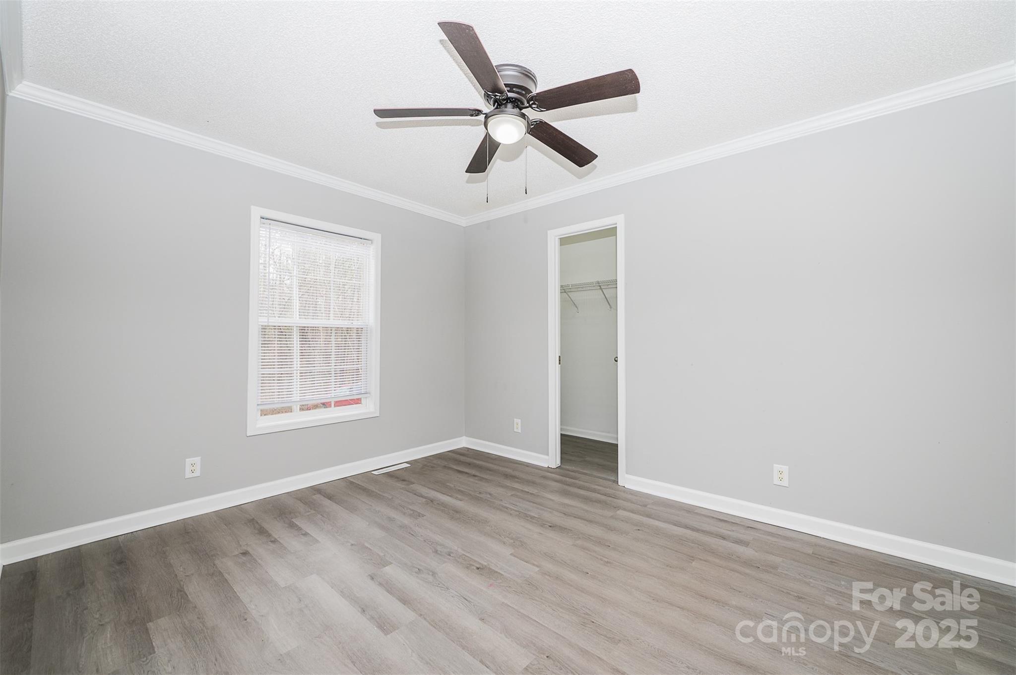 8226 Malibu Road Mount Pleasant, NC 28124 - Photo 23 of 44 an empty room with wooden floor ceiling fan and windows