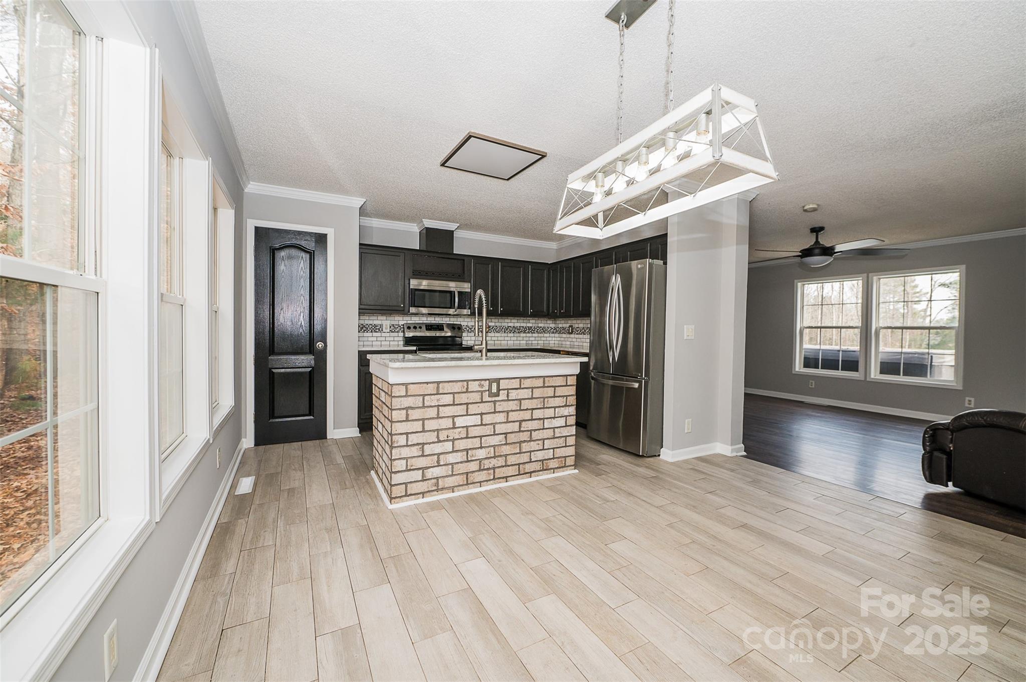 8226 Malibu Road Mount Pleasant, NC 28124 - Photo 9 of 44 a kitchen with stainless steel appliances kitchen island granite countertop a refrigerator a stove and a wooden floors
