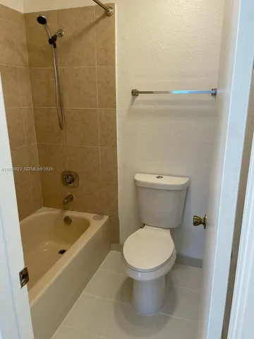 a white toilet sitting next to a bath tub