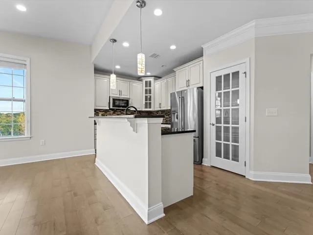 a kitchen with stainless steel appliances granite countertop a refrigerator a stove a sink and a microwave