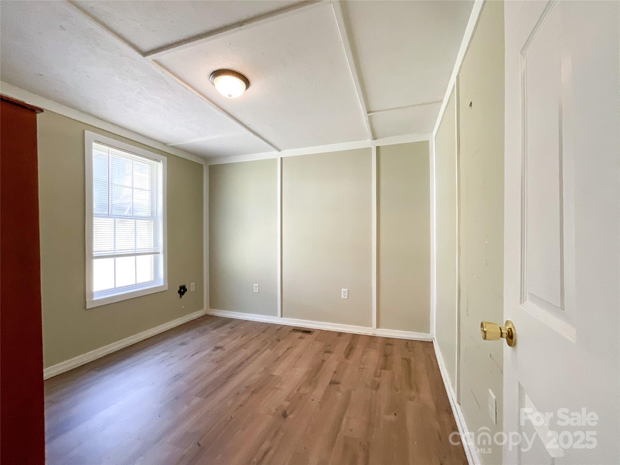680 Mullinax Circle Blacksburg, SC 29702 - Photo 10 of 25 a view of an empty room with wooden floor and a window