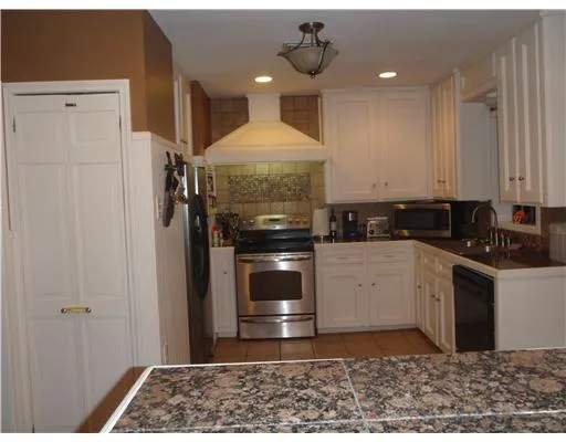a kitchen with a stove and white cabinets