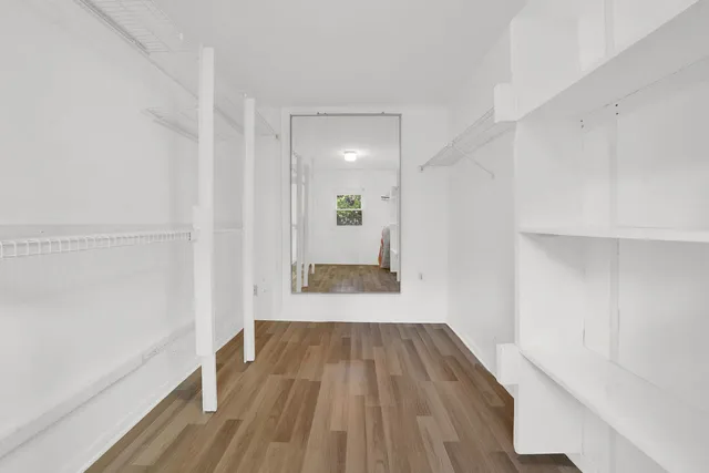 a view of a room with wooden floor and a window