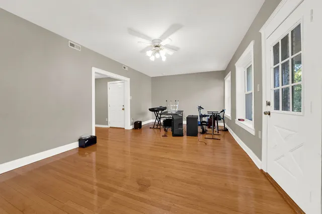 wooden floor with white walls and chandelier