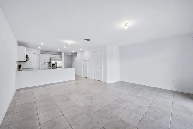 a view of kitchen with kitchen island white cabinets and refrigerator