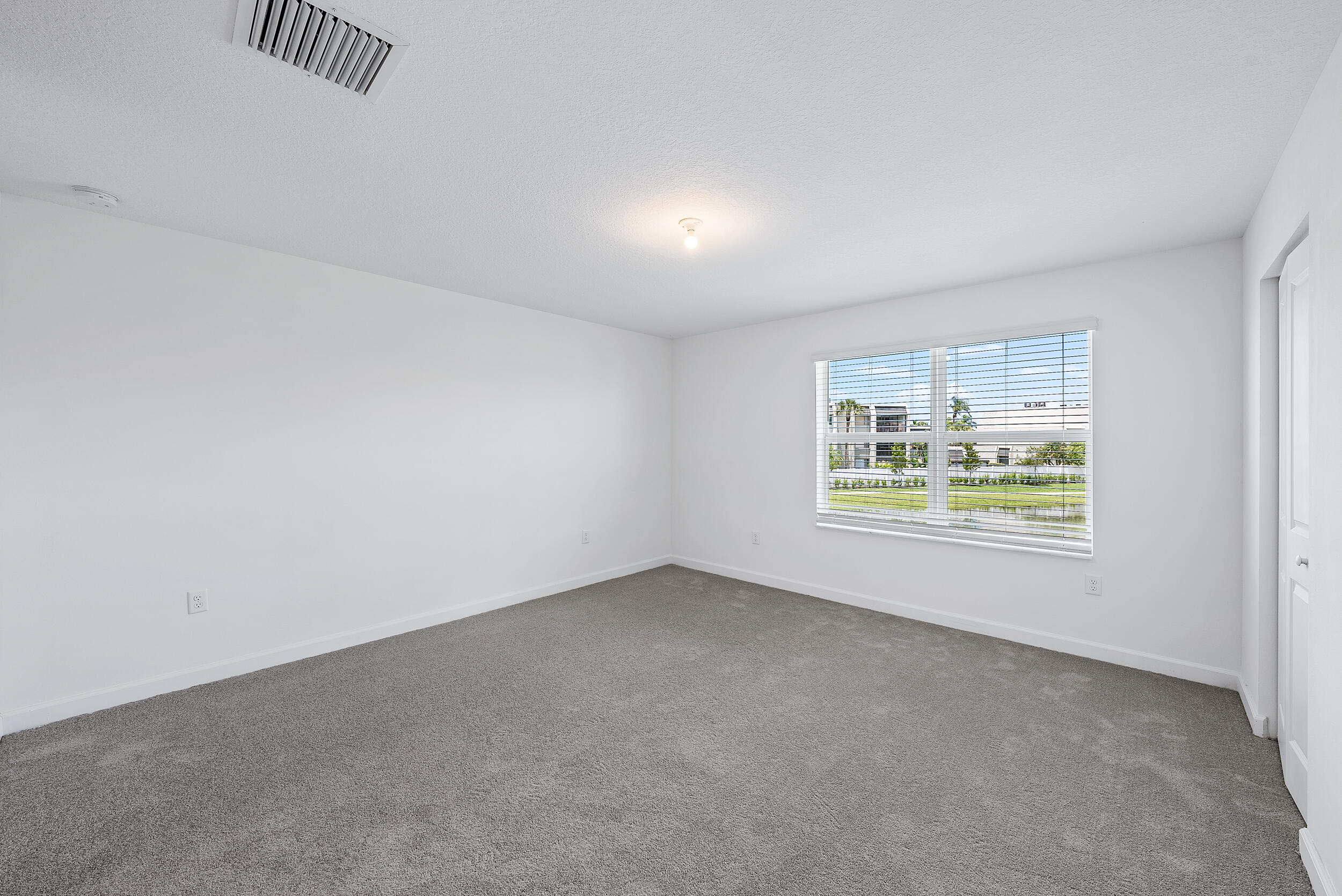 4215 Bent River Road Lake Worth, FL 33467 - Photo 17 of 29 an empty room with windows and painted walls