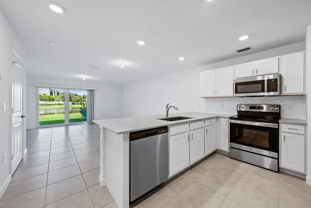 a kitchen with a sink cabinets and stainless steel appliances