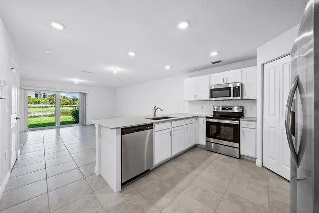 a kitchen with stainless steel appliances a refrigerator sink and stove