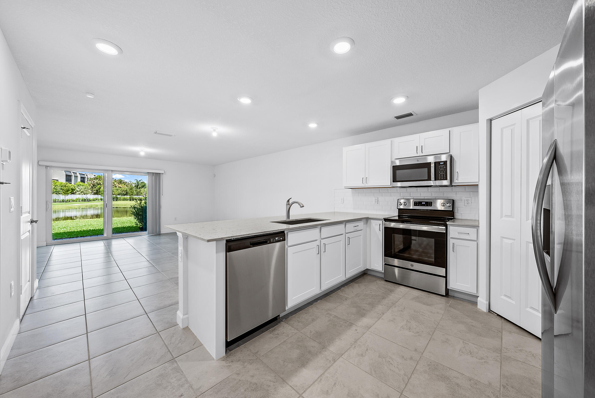 4215 Bent River Road Lake Worth, FL 33467 - Photo 6 of 29 a kitchen with stainless steel appliances a refrigerator sink and stove