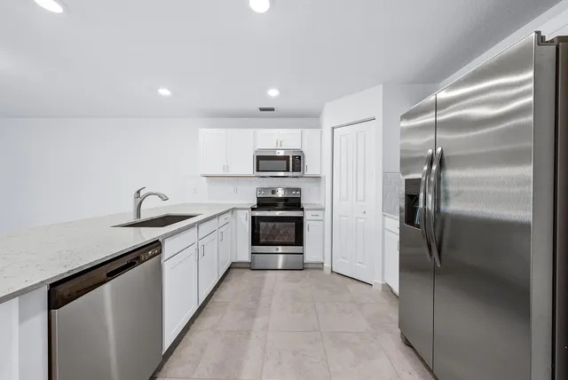 a kitchen with granite countertop a refrigerator and a sink