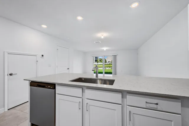 a kitchen with stainless steel appliances white cabinets and a potted plant