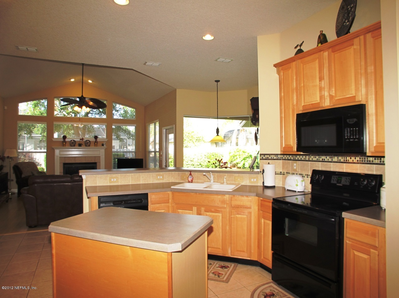1645 Margarets Walk Road Fleming Island, FL 32003 - Photo 12 of 42 a kitchen with stainless steel appliances kitchen island granite countertop a stove a sink and a microwave