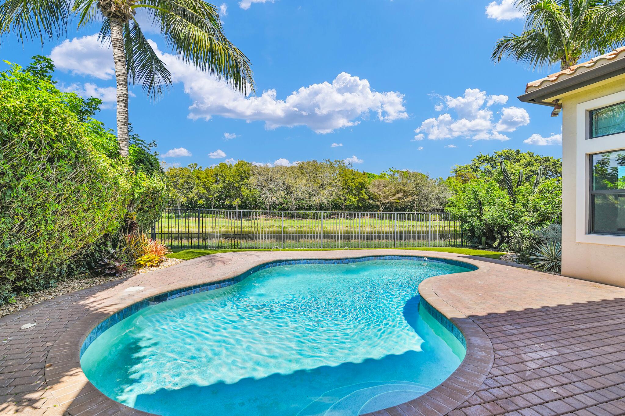 9577 Eden Roc Court Delray Beach, FL 33446 - Photo 22 of 53 a view of a swimming pool with a yard and a garden