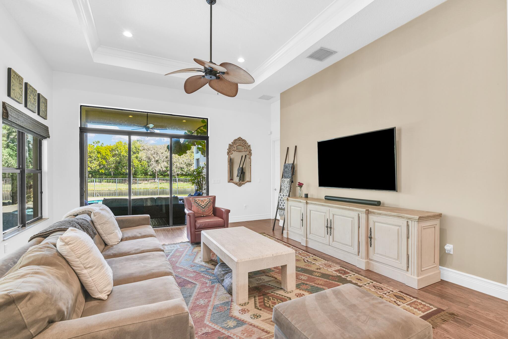 9577 Eden Roc Court Delray Beach, FL 33446 - Photo 6 of 53 a living room with furniture a flat screen tv and a large window
