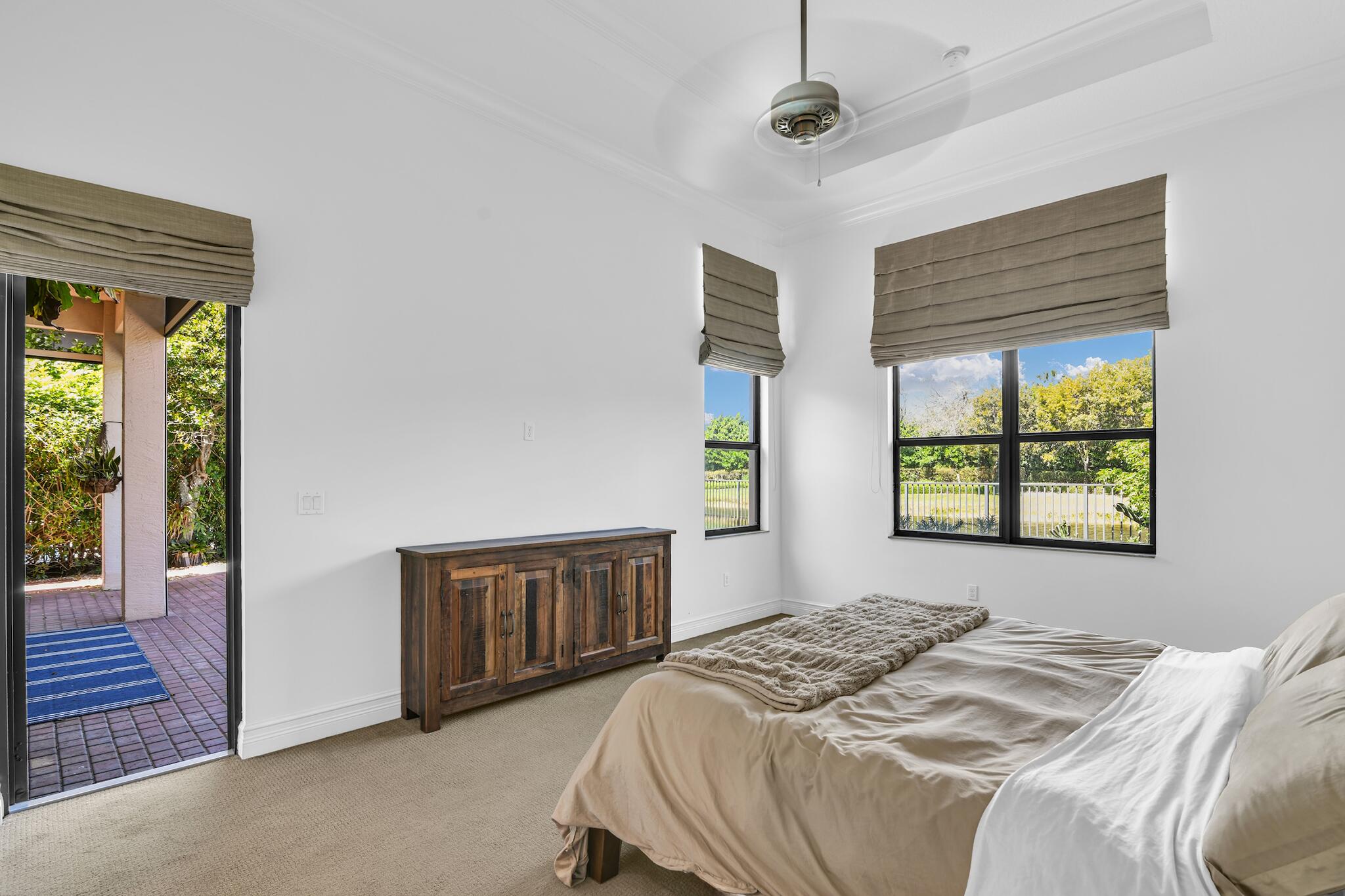 9577 Eden Roc Court Delray Beach, FL 33446 - Photo 8 of 53 a bedroom with a balcony a bed and a window