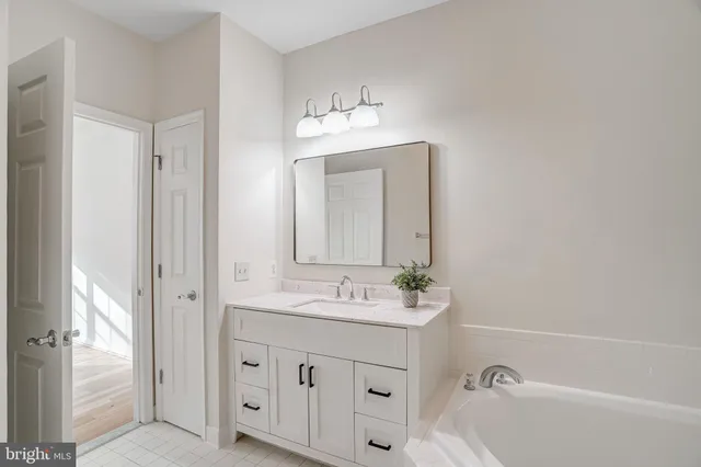 a bathroom with a sink tub and a mirror