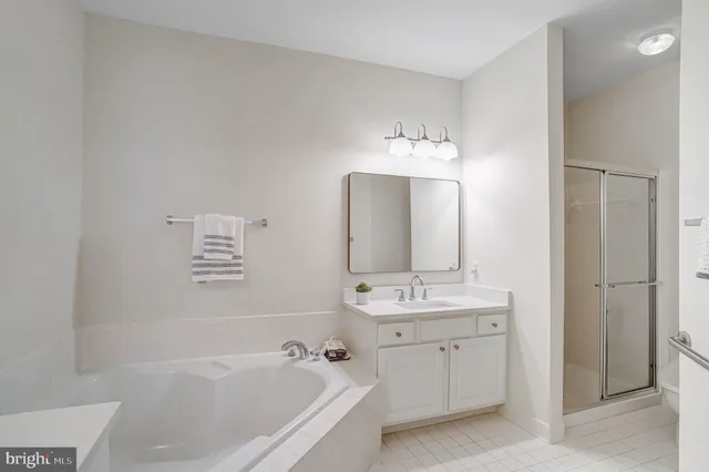 a spacious bathroom with a double vanity sink mirror and bathtub