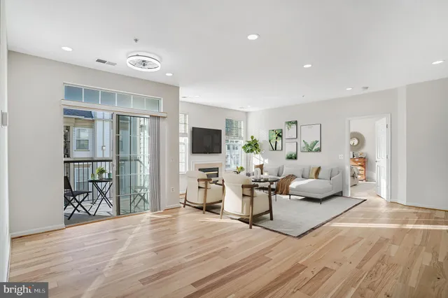 a living room with furniture mirror and a flat screen tv