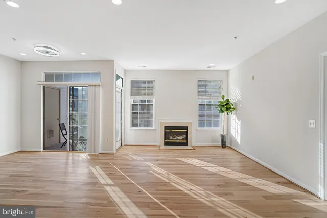 a view of a livingroom with a fireplace a potted plant and wooden floor