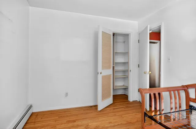 a view of bedroom with closet and wooden floor