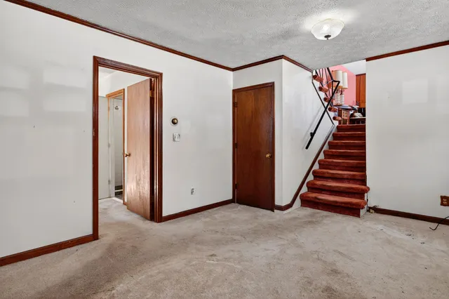 a view of an empty room with stairs and stairs