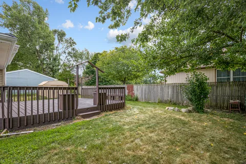 a view of a backyard with a small cabin and a chair