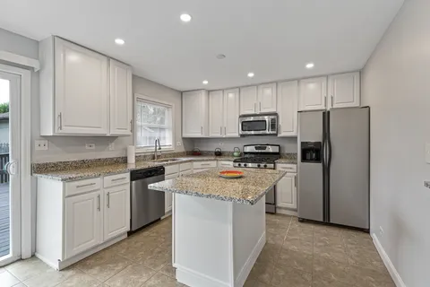 a kitchen with stainless steel appliances granite countertop a refrigerator stove microwave and sink