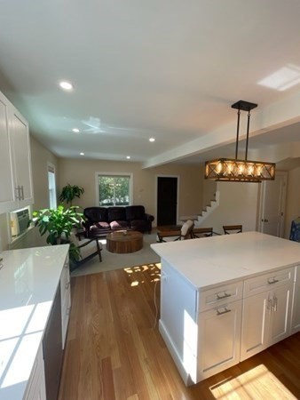 47 Bow Street Saugus, MA 01906 - Photo 25 of 31 a large white kitchen with a stove a sink dishwasher and a dining table with garden view