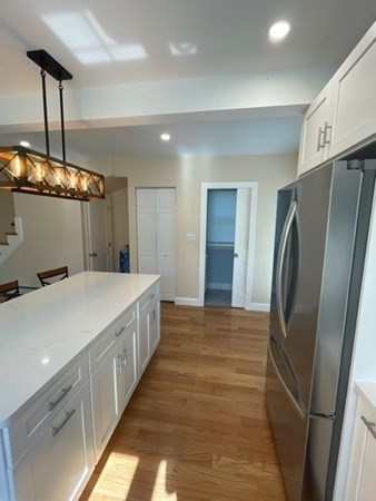 47 Bow Street Saugus, MA 01906 - Photo 27 of 31 a kitchen with stainless steel appliances a refrigerator and a wooden floor