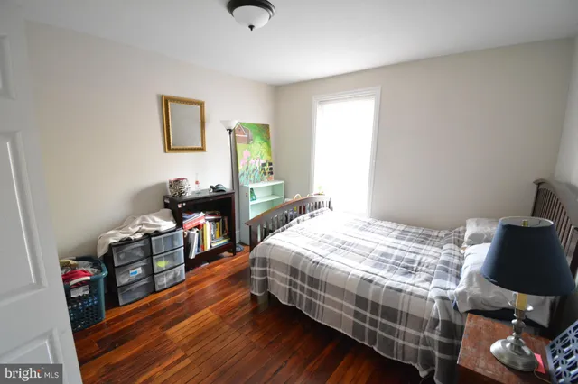 a bedroom with a bed and a wooden floor