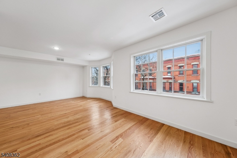 52 James Street, Unit 3 Newark, NJ 07102 - Photo 7 of 25 a view of an empty room with wooden floor and a window