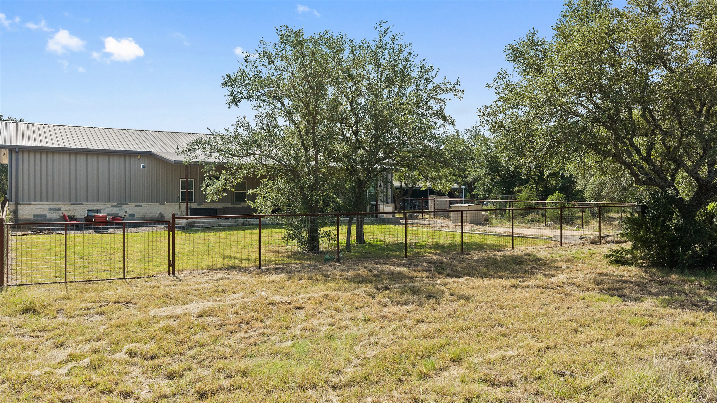 764 Stubbs Road Johnson City, TX 78636 - Photo 16 of 29 A fenced backyard with mature trees offers a private, serene outdoor living space.