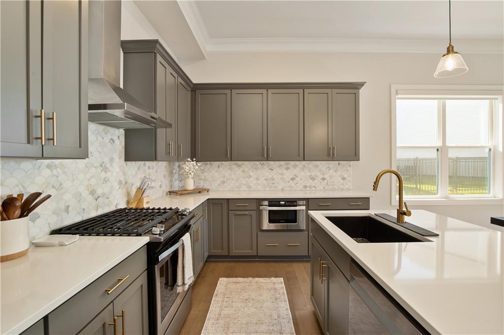 a kitchen with stainless steel appliances granite countertop a sink stove and refrigerator