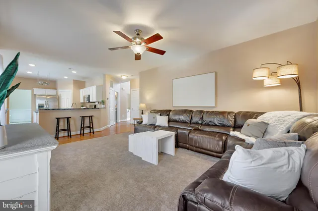 a living room with furniture and a view of kitchen