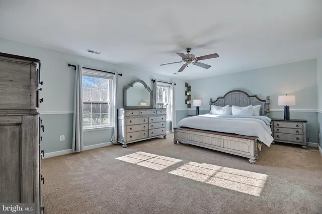a spacious bedroom with a bed a window and closet