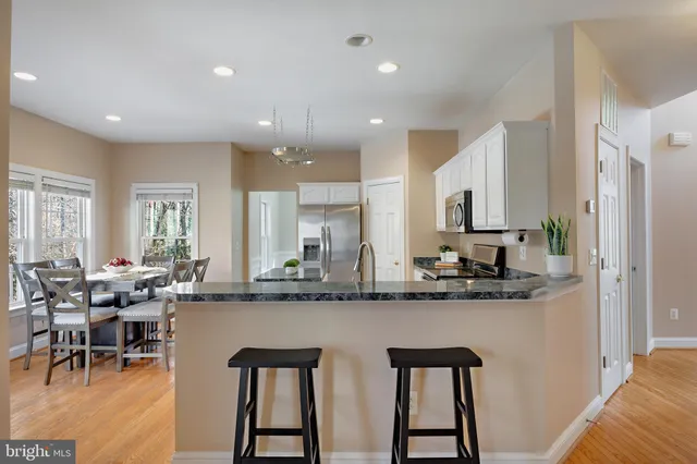 a living room with furniture and a view of kitchen