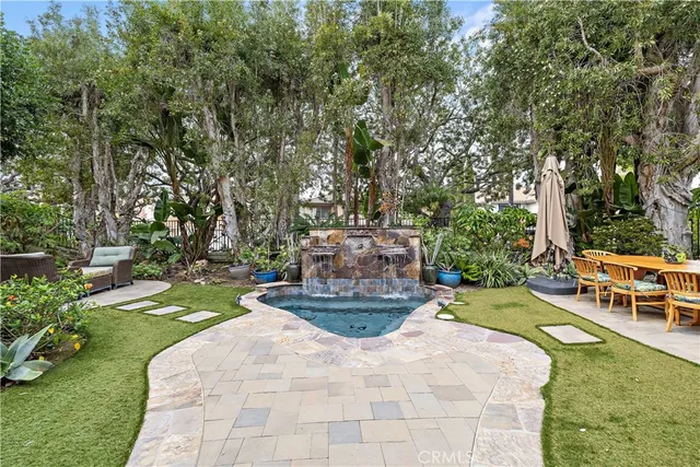 a view of a patio with table and chairs potted plants and large tree